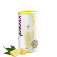 Ein Precon-Zitronen-Joghurt-Shake-Behälter mit gelbem Deckel steht aufrecht. Das Etikett zeigt einen Shake-Spritzer, lila und gelben Text und zwei Zitronenscheiben mit grünen Blättern davor.