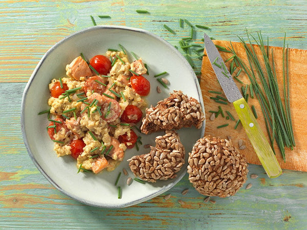 Huevos revueltos con salmón y tomate con panecillo integral