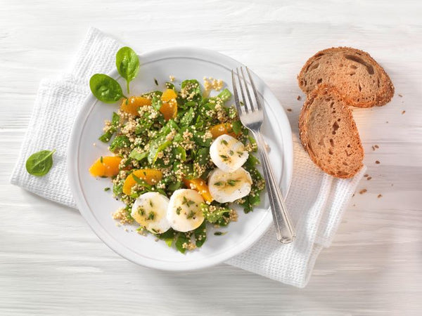 Insalata di spinaci con quinoa, condimento all'arancia e formaggio di capra